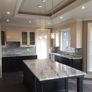 This is an example of a mid-sized transitional u-shaped kitchen pantry in Vancouver with a double-bowl sink, recessed-panel cabinets, black cabinets, granite benchtops, grey splashback, stainless steel appliances, dark hardwood floors, with island and brown floor.