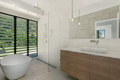 Large modern family bathroom in Cairns with a freestanding bath, a walk-in shower, white tiles, porcelain tiles and a built-in sink.