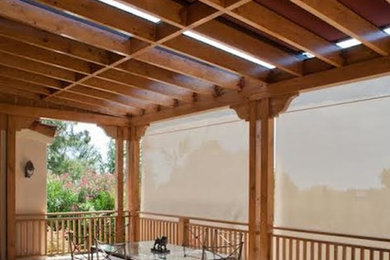 Large elegant backyard stamped concrete patio photo in Los Angeles with a pergola