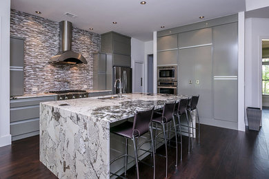 Example of a mid-sized minimalist l-shaped dark wood floor kitchen design in Atlanta with an undermount sink, flat-panel cabinets, gray cabinets, granite countertops, metallic backsplash, metal backsplash, stainless steel appliances and an island