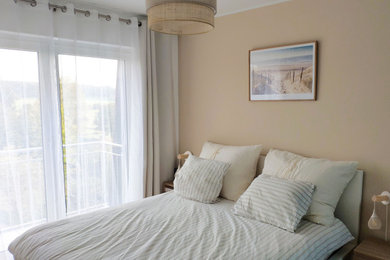 Cette photo montre une chambre parentale beige et blanche bord de mer avec un mur beige, parquet clair, aucune cheminée et un sol marron.