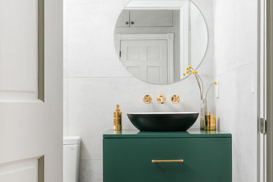 Small contemporary powder room in Boston with flat-panel cabinets, green cabinets, gray tile, a vessel sink, grey floor, green benchtops, a freestanding vanity and wallpaper.