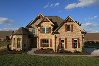 Mid-sized arts and crafts brown two-story brick exterior home photo in Other
