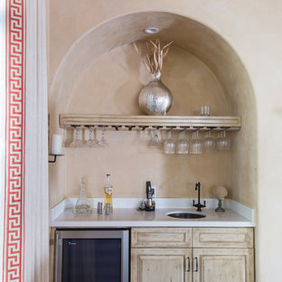 Ejemplo de salón con barra de bar cerrado, mediterráneo, de tamaño medio, con paredes beige, suelo de madera oscura y suelo marrón