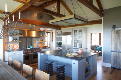 Example of a classic medium tone wood floor kitchen design in Boston with a farmhouse sink, recessed-panel cabinets, gray cabinets, granite countertops, stainless steel appliances and two islands