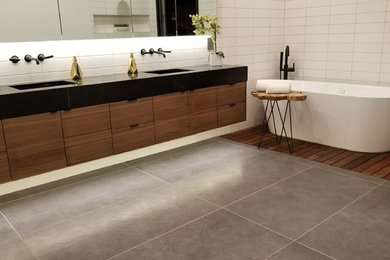 Freestanding bathtub - large contemporary master white tile and porcelain tile concrete floor and gray floor freestanding bathtub idea in Phoenix with flat-panel cabinets, dark wood cabinets, white walls, an undermount sink, quartz countertops and black countertops