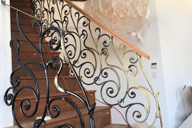 Custom made semi-circle ornamental iron staircase railings with wooden top.