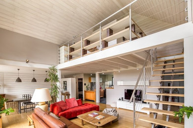 Inspiration pour une salle de séjour mansardée ou avec mezzanine design de taille moyenne avec un mur blanc, parquet clair et un sol marron.