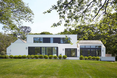 Example of a country white two-story house exterior design in New York