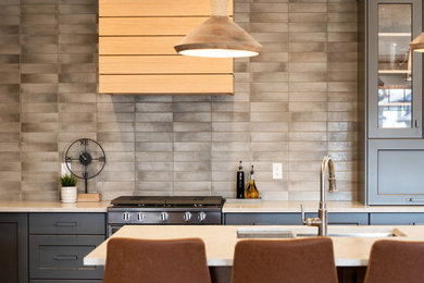 Mid-century modern l-shaped medium tone wood floor kitchen photo in Toronto with quartz countertops, brown backsplash, black appliances, an island and beige countertops