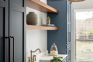 Dedicated laundry room - mid-sized transitional wallpaper dedicated laundry room idea in Tampa with an undermount sink, shaker cabinets, blue cabinets, quartz countertops and white countertops