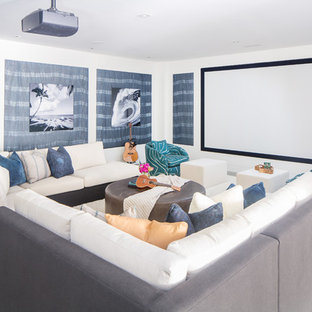 Home theater - beach style concrete floor and gray floor home theater idea in Orange County with white walls and a projector screen