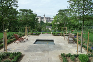 Design ideas for a large contemporary patio in Frankfurt with natural stone pavers.