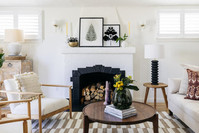 Example of a tuscan light wood floor living room design in Los Angeles with white walls and a standard fireplace