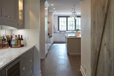 Kitchen pantry - huge cottage porcelain tile and brown floor kitchen pantry idea in Chicago with gray cabinets, marble countertops, mirror backsplash, stainless steel appliances, a double-bowl sink, white backsplash, an island and shaker cabinets