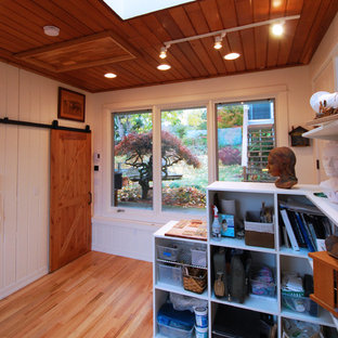 Design ideas for a small modern home studio in Other with white walls, light hardwood flooring and no fireplace.