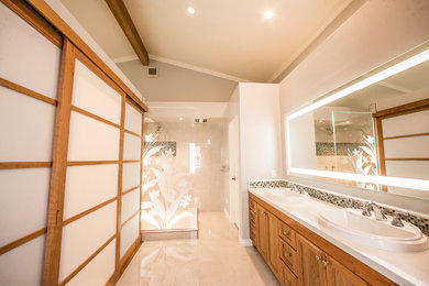 Example of a mid-sized transitional master beige tile and porcelain tile ceramic tile and beige floor bathroom design in Orange County with recessed-panel cabinets, dark wood cabinets, a two-piece toilet, beige walls, a drop-in sink and solid surface countertops