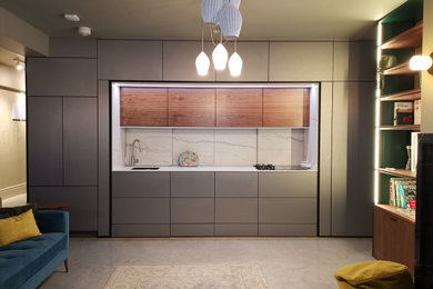 This is an example of a small modern grey and brown single-wall enclosed kitchen in London with a single-bowl sink, flat-panel cabinets, stainless steel cabinets, engineered stone countertops, white splashback, engineered quartz splashback, black appliances, concrete flooring, no island, grey floors, white worktops, a drop ceiling and feature lighting.