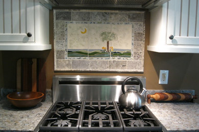 Example of an arts and crafts medium tone wood floor kitchen design in Other with raised-panel cabinets, multicolored backsplash, ceramic backsplash, stainless steel appliances and multicolored countertops