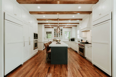 Inspiration for a large transitional u-shaped medium tone wood floor, brown floor and exposed beam eat-in kitchen remodel in Other with a single-bowl sink, recessed-panel cabinets, white cabinets, quartz countertops, white backsplash, marble backsplash, stainless steel appliances, an island and white countertops