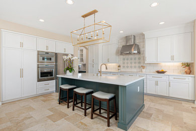 Example of a large trendy l-shaped travertine floor and beige floor open concept kitchen design in San Diego with an undermount sink, shaker cabinets, white cabinets, quartz countertops, white backsplash, subway tile backsplash, stainless steel appliances, an island and white countertops