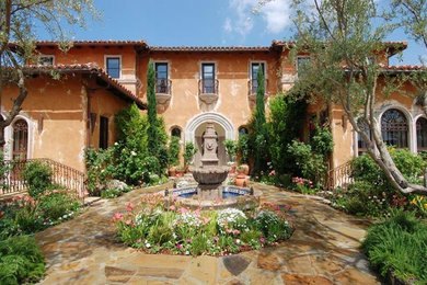 Huge tuscan brown two-story stucco exterior home photo in Los Angeles