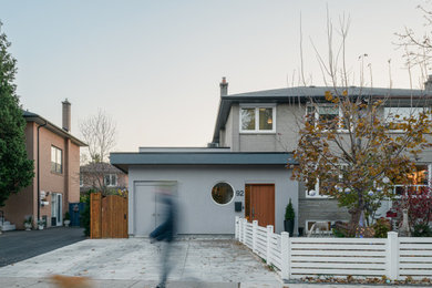Modelo de fachada de casa gris minimalista de tamaño medio de dos plantas con revestimiento de estuco