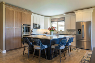 Inspiration for a contemporary l-shaped medium tone wood floor and beige floor kitchen remodel in Denver with stainless steel appliances and an island