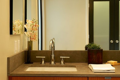 Example of a large trendy master beige tile and porcelain tile porcelain tile corner shower design in Boston with an undermount sink, flat-panel cabinets, medium tone wood cabinets and beige walls