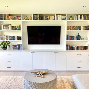 Design ideas for a mid-sized shabby-chic style enclosed home theatre in Brisbane with grey walls, porcelain floors, a wall-mounted tv and grey floor.