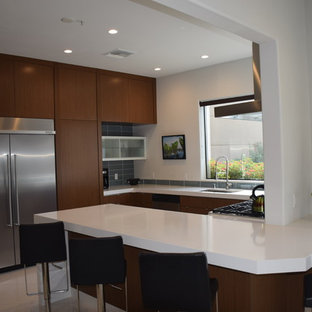 Photo of a mid-sized modern l-shaped kitchen pantry in Los Angeles with an undermount sink, flat-panel cabinets, brown cabinets, quartz benchtops, blue splashback, glass tile splashback, stainless steel appliances, terrazzo floors and with island.