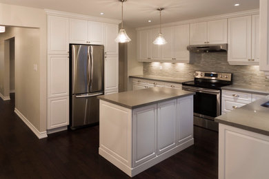 Eat-in kitchen - mid-sized transitional l-shaped dark wood floor and brown floor eat-in kitchen idea in Toronto with a double-bowl sink, raised-panel cabinets, white cabinets, quartz countertops, gray backsplash, glass tile backsplash, stainless steel appliances, an island and gray countertops