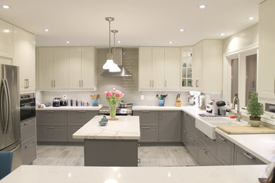 Example of a large transitional u-shaped gray floor eat-in kitchen design in Toronto with a farmhouse sink, gray backsplash, glass tile backsplash and two islands