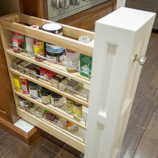 Inspiration pour une arrière-cuisine design en U de taille moyenne avec un évier encastré, un placard avec porte à panneau surélevé, une façade en inox, un plan de travail en granite, une crédence grise, une crédence en carreau de verre, un électroménager en acier inoxydable, un sol en bois foncé et un îlot central.