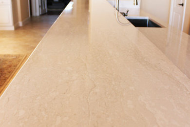 Inspiration for a large contemporary galley porcelain tile and beige floor open concept kitchen remodel in Tampa with an undermount sink, raised-panel cabinets, medium tone wood cabinets, quartz countertops, blue backsplash, glass tile backsplash, stainless steel appliances, a peninsula and white countertops