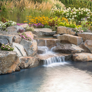 beautiful plantings soften this rustic waterfall and pool