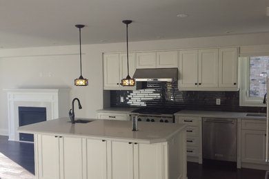 Photo of a modern eat-in kitchen in Toronto with black splashback and with island.
