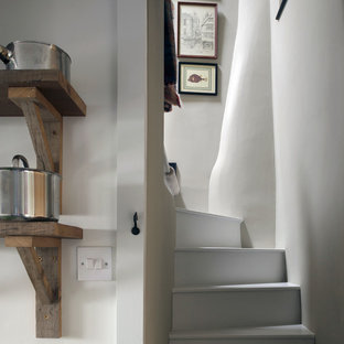 Small rural painted wood curved staircase in Cornwall with painted wood risers.