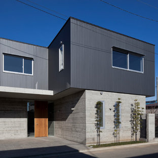 他の地域のモダンスタイルのおしゃれな家の外観 (コンクリートサイディング、グレーの外壁、陸屋根、戸建、混合材屋根) の写真
