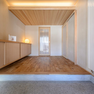 他の地域のアジアンスタイルのおしゃれな玄関ホール (白い壁、無垢フローリング、茶色い床) の写真
