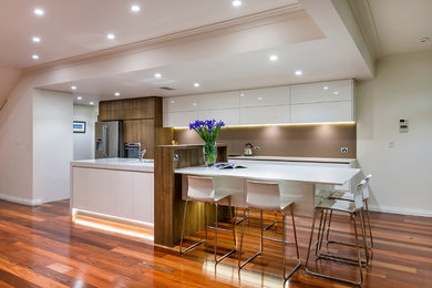 Inspiration for a large contemporary galley eat-in kitchen in Perth with an undermount sink, flat-panel cabinets, white cabinets, quartz benchtops, brown splashback, porcelain splashback, stainless steel appliances, dark hardwood floors and with island.