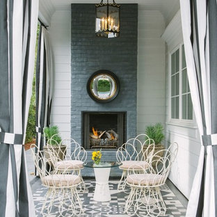 This is an example of a traditional patio in New York with a roof extension and with fireplace.