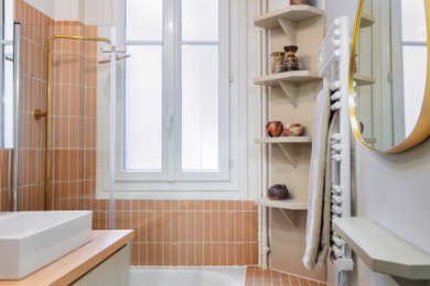 Inspiration pour une petite salle de bain principale design avec des carreaux de céramique, carreaux de ciment au sol, un plan de toilette en bois, des portes de placard blanches, meuble simple vasque, meuble-lavabo encastré, une baignoire d'angle, un combiné douche/baignoire, un carrelage rose, un mur rose, un lavabo posé, un sol multicolore et une cabine de douche à porte battante.