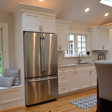Kitchen with White Frameless Cabinets and Stainless Refrigerator