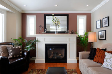 This is an example of a mid-sized transitional open concept living room in Ottawa with medium hardwood floors, a standard fireplace and a wood fireplace surround.