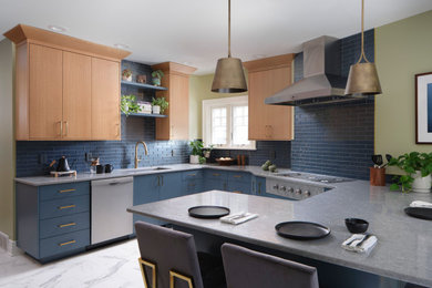 Foto på ett funkis kök, med en undermonterad diskho, släta luckor, bänkskiva i kvarts, blått stänkskydd, stänkskydd i glaskakel, rostfria vitvaror och klinkergolv i porslin