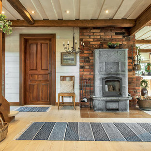 Inspiration för en mellanstor lantlig hall, med vita väggar och ljust trägolv