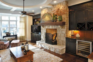 Large mountain style enclosed dark wood floor living room photo in Other with beige walls, a standard fireplace, a stone fireplace and a tv stand