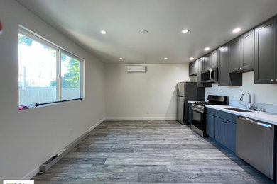 Inspiration for a mid-sized modern laminate floor eat-in kitchen remodel in Los Angeles with gray cabinets, quartzite countertops, white backsplash, stainless steel appliances and white countertops