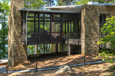 Mid-sized modern two-storey brown exterior in Atlanta with stone veneer and a flat roof.